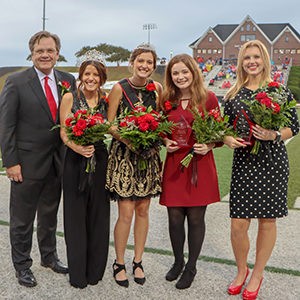 Homecoming winners together holding flowers.