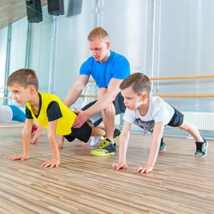 Children At Physical Education Lesson In School Gym